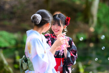 浴衣を着た日本人の小学生の女の子がシャボン玉で遊ぶ夏の風景