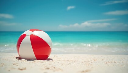 Vibrant red and white striped beach ball rests on sandy shore next to tranquil turquoise ocean waves. Offers summer fun, relaxation, vacation vibes, sunshine activity, and playful enjoyment.