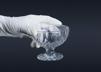 A Close-up of a Hand Wearing a Sterile White Rubber Glove Delicately Holding a Clear, Patterned...