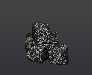 A Detailed Studio Close-up of a Small Stack of Three Dark, Rustic Cubes, a Healthy and Natural Snack