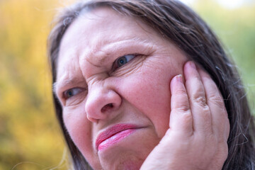 Suffering woman in pain touching jaw, toothache, painful tooth, gum swelling, worried expression,...
