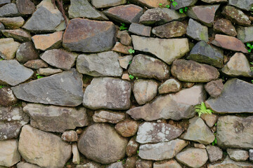Stacked stone brick wall. Stone cladding wall made of striped stacked slabs of natural grey rocks. Pattern of decorative slate stone wall surface. Stone pattern background