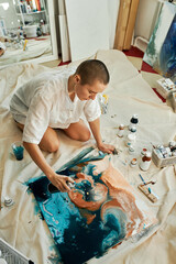 Vertical from above shot of creative young woman spending time in studio working on abstract...