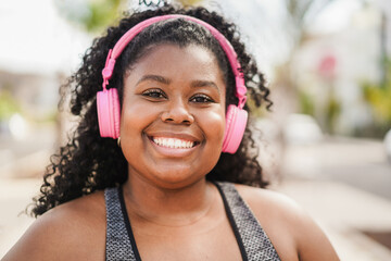 Happy curvy african woman doing sport workout routine outdoor - Fitness and healthy lifestyle concept - Main focus on nose