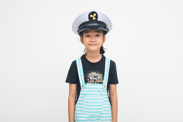 A relaxed young Asian girl smiling joyfully while wearing a pilot cap, radiating warm and lighthearted vibes in her expression. Isolated on a white background.