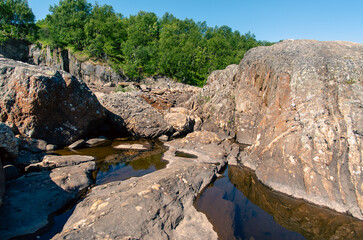 streams of clear waterfall water and stone banks of a mountain river