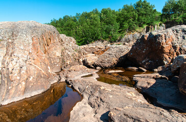 streams of clear waterfall water and stone banks of a mountain river