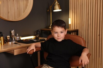 Cute little boy with wet hair in barbershop