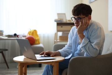 Tired student preparing for exam at table indoors