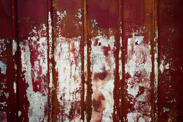 Close-up of Rusted Red Metal Surface with Peeling Paint and Vertical Ridges