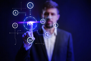 Professional engaging with HR technology interface in a business setting during evening hours