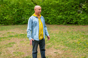 happy positive caucasian mature senior man 60-65 years old smiling on natural background, good...