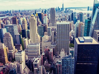 Fototapeta premium An expansive aerial view captures the dense urban landscape of a modern city, showcasing numerous skyscrapers and buildings under a bright sky