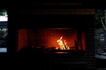Cozy living room with a modern stone fireplace, warm flames flickering inside, creating an inviting...