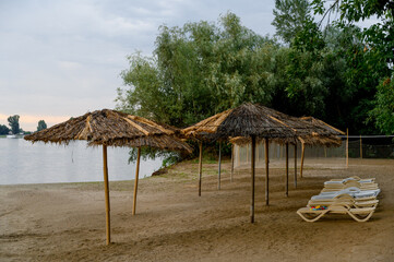 River bank with beach umbrellas and trees