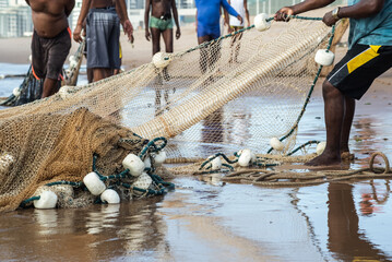 Half body of unidentified fishermen pulling a fishing net. Fishing hobby.