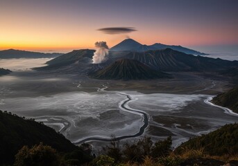 Dramatic landscape of Mount Bromo volcano in East Java, Indonesia. Volcanic smoke and ash clouds rise above the crater, surrounded by mist and mountains. Perfect for adventure, geology, and travel the