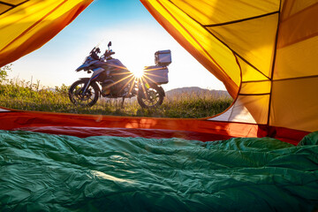 Motorcycle trip to the mountains with a tent. Beautiful sunset in the mountains.