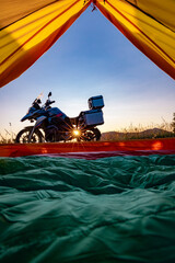 Camping with a motorcycle with a yellow tent in the mountains.