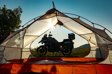Moto trip on a motorcycle, camping in a tent in the mountains.