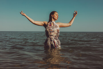 Beautiful woman in dress standing in the sea