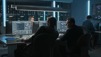 Several IT Engineers Work Together at Desks, Analyzing Code. Group Focuses on Technical Problem solving and System Management, Using Advanced Software Tools - Powered by Adobe