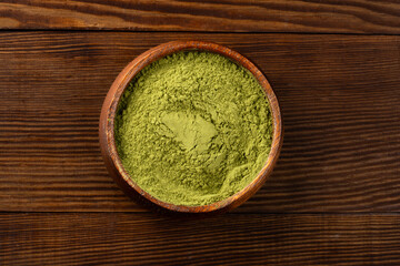Henna, wheat grass or matcha powder on wooden background
