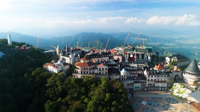 Construction cranes towering over ba na hills highlight ongoing expansion in the mountaintop resort near da nang, blending french inspired architecture with stunning natural beauty