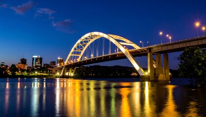Naklejka premium Illuminated arch bridge at night over a river