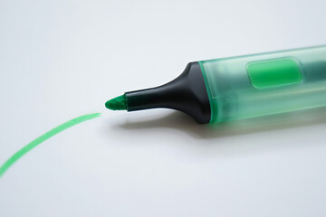 Fototapeta premium Green highlighter marking a line on a white surface