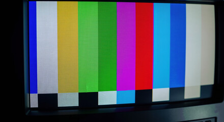 Television screen displaying colorful test pattern bars for broadcast signal calibration. Media technology equipment for technical and electronic services