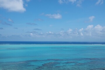 Obraz premium Calm turquoise ocean under blue sky with clouds, tropical seascape horizon, travel and summer background.