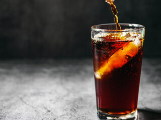 Pouring of Cola and Ice, Cola soft drink with ice cubes, soda fizzy drink in Cold glass