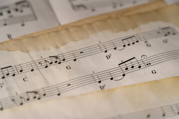 Close-Up of vintage sheet music featuring chords, notes, and aged paper texture – A timeless...