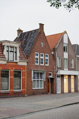 Row of residential buildings showing variations in architectural style with brick facades and tiled roofs.
