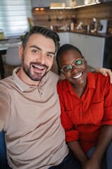 Fototapeta premium Happy multi-ethnic couple taking a selfie at home