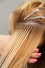 Hair extension process with blonde strands close-up