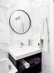 Bathroom interior. Modern white sink with faucet and mirror and white marble walls. Modern interior.