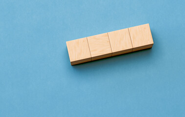 Four Wooden Blocks Arranged on a Blue Background Showing Minimalistic Design and Geometric Shapes