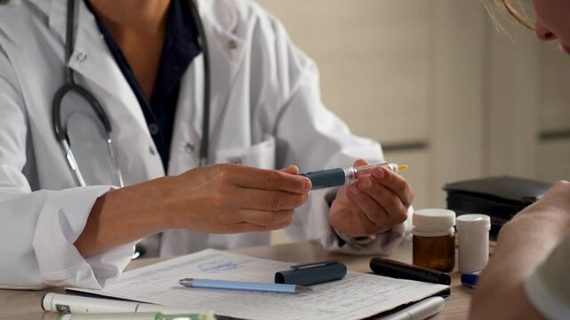 Doctor consulting patient with insulin pen and diabetes medication