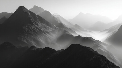 Monochromatic photograph showcasing a mountain range shrouded in a misty atmosphere view