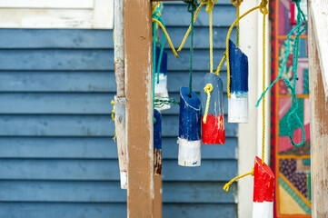 Decorative wooden buoys painted in bold red, white, and blue hang from ropes on Fogo Island, adding a touch of coastal character against the backdrop of village life and Atlantic heritage.