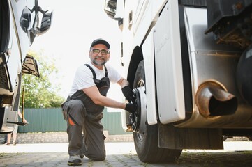 A senior worker checks wheel. Truck malfunction. Service work