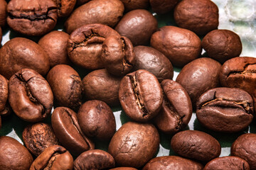 Close-up of roasted coffee beans with rich brown shades. The glossy texture and natural cracks...