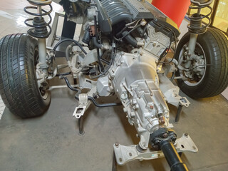 Car suspension and transmission system with visible wheels and gears. Mechanical automotive detail highlighting stability and engineering.