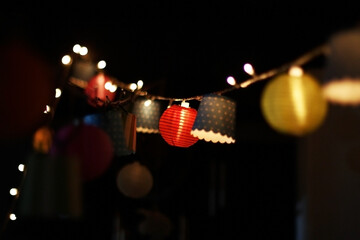 Colorful paper lanterns and string lights illuminating night