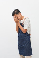 Young handsome asian man wearing apron over isolated white background with sad expression covering...