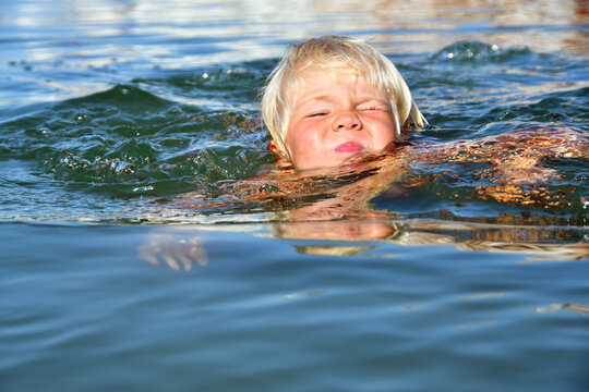 Little boy learning to swim in the sea