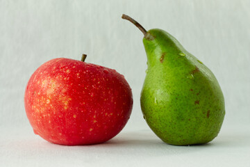 Vibrant red apple and juicy green pear with fresh water drops, isolated on a perfect white background. Concept of healthy eating, organic food, and vitamins. Ideal for banners with copy space.