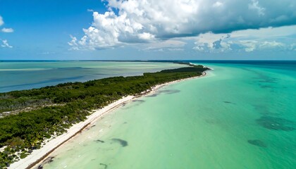 A breathtaking aerial view showcases a pristine beach, lush vegetation, and tranquil turquoise waters.